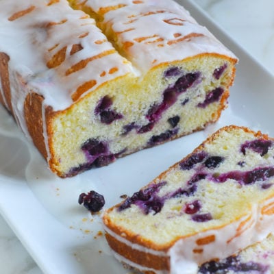 Loaf of lemon blueberry pound cake with some slices removed.