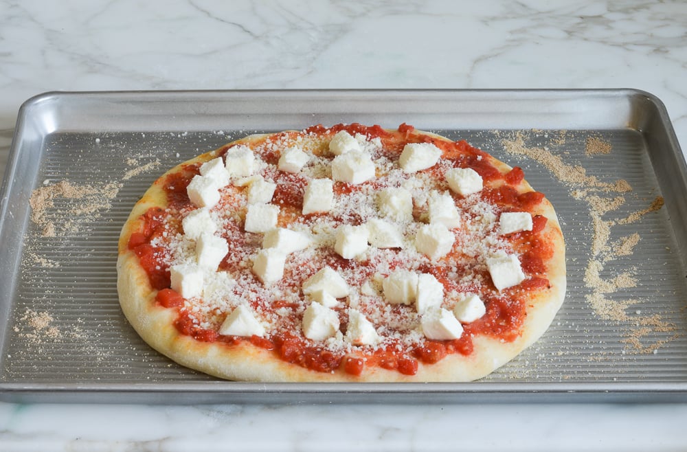Chunks of cheese on a pizza.