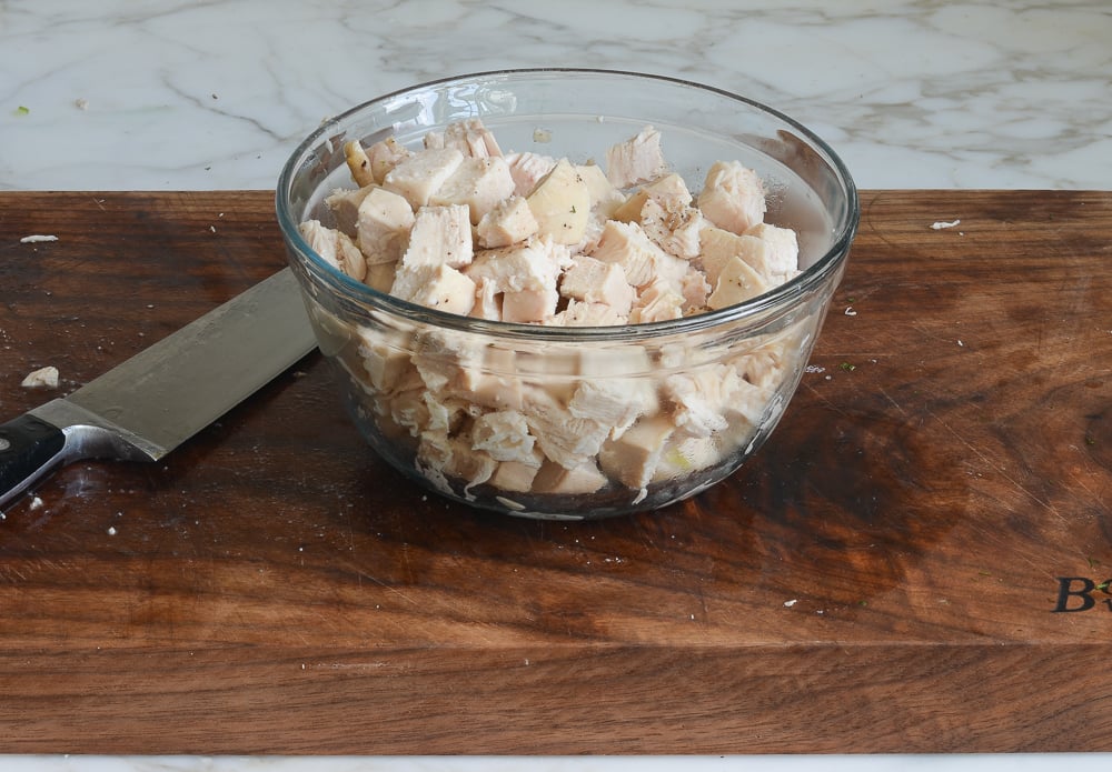 Glass bowl of diced chicken.