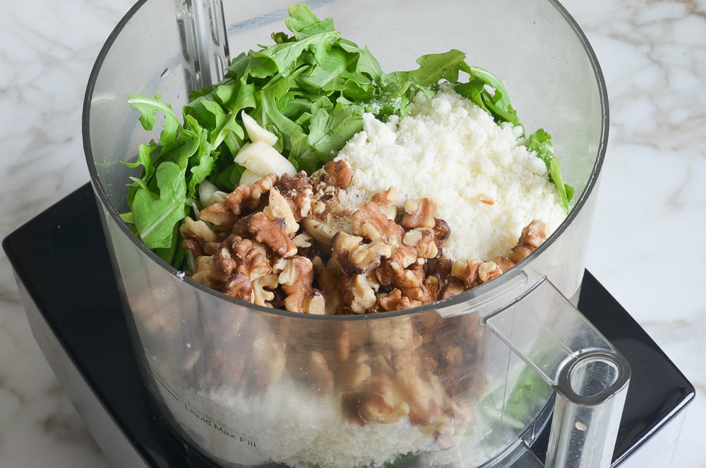 arugula, walnuts, cheese, and garlic in food processor