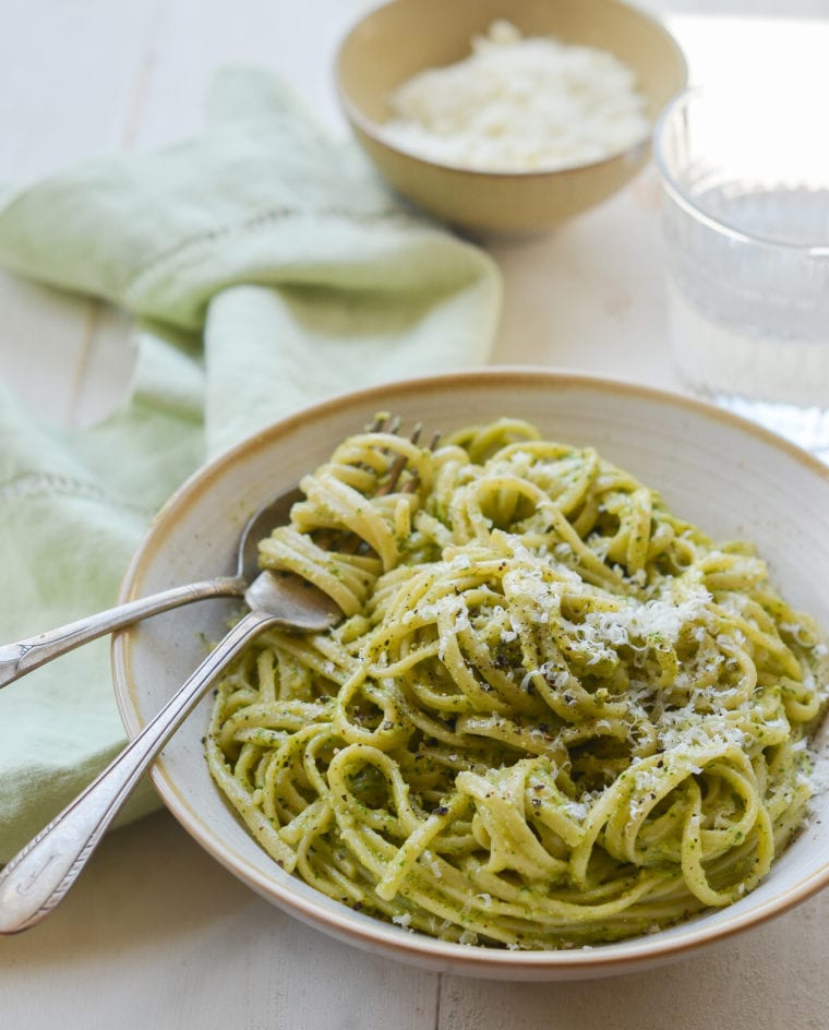 Fork on a plate with linguine with creamy arugula walnut pesto.