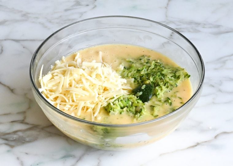adding zucchini and cheese to egg mixture