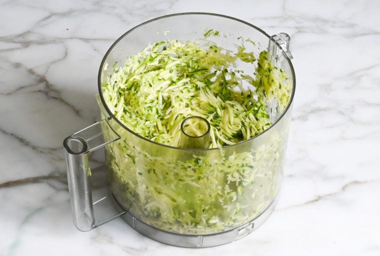 Shredded zucchini in a food processor.