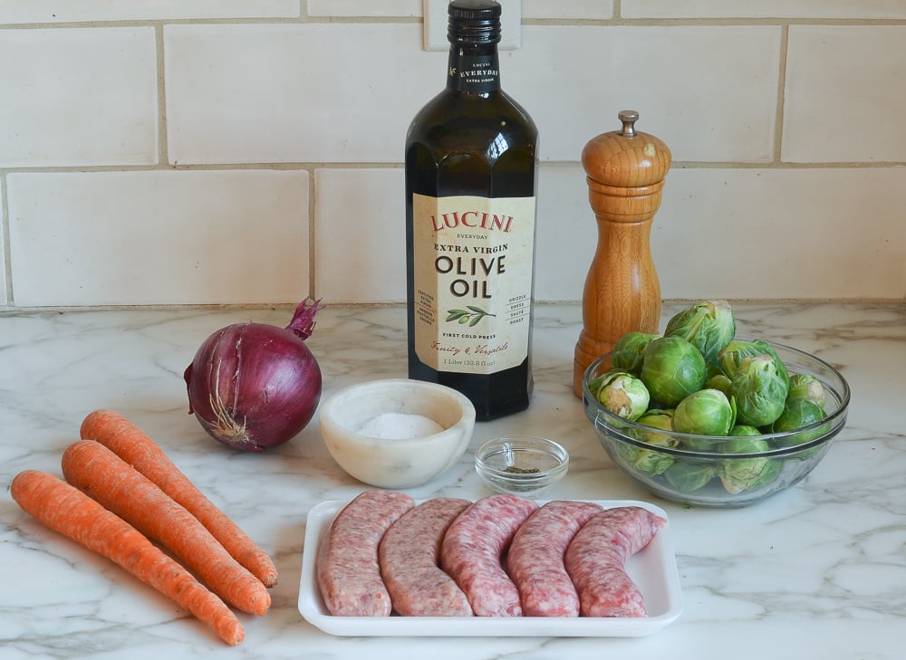 Sheet pan sausage and vegetables ingredients on a counter. 