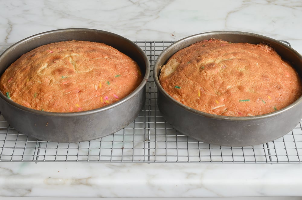 baked sprinkle cake layers on cooling rack