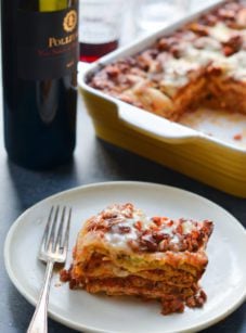 Slice of lasagna on a plate with a fork.