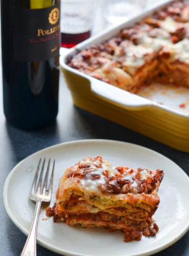 Slice of lasagna on a plate with a fork.