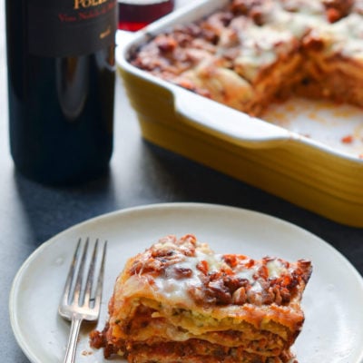Slice of lasagna on a plate with a fork.