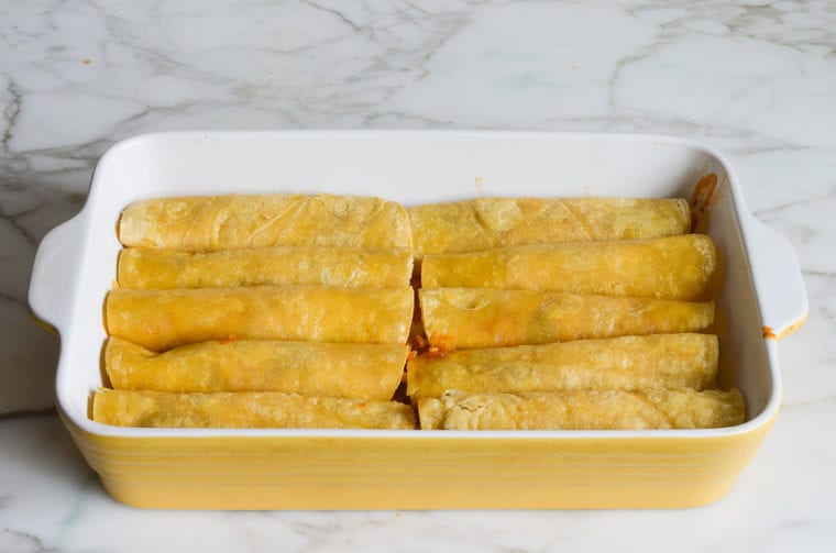 rolled enchiladas arranged in the baking dish