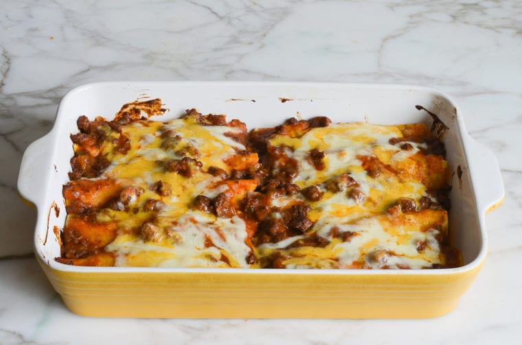 Baking dish of bubbling enchiladas.