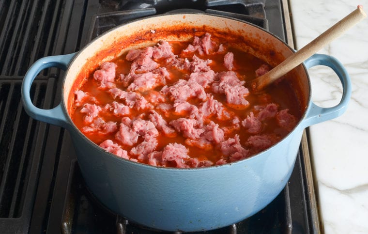 adding the remaining turkey to the chili.