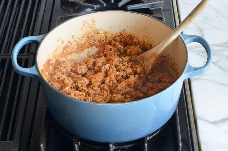 partially cooked turkey with vegetables and spices in pot.