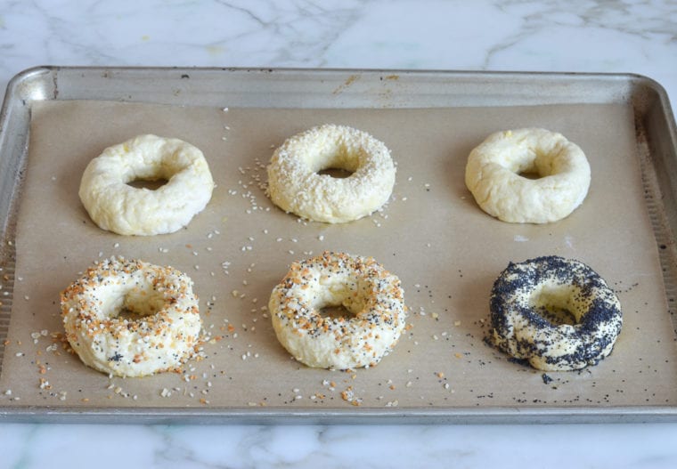 sprinkling toppings on bagels