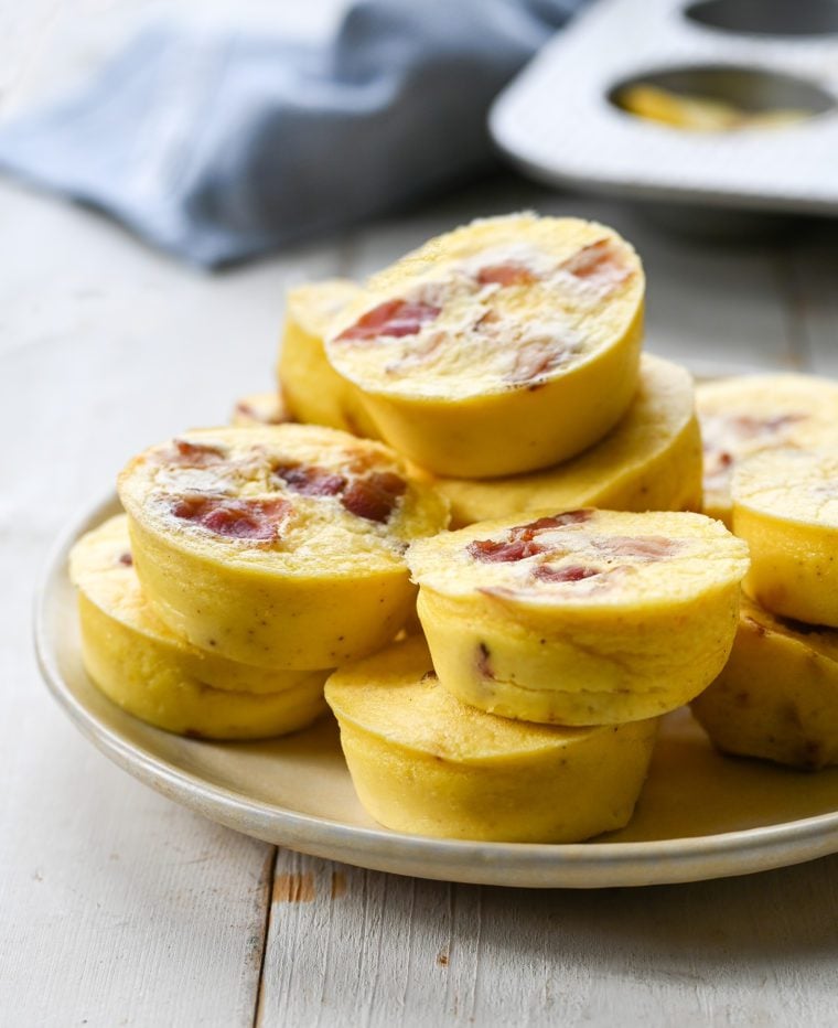 Egg bites with bacon and gruyere piled on a plate.