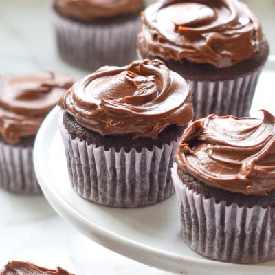 Chocolate cupcakes on an elevated serving dish.