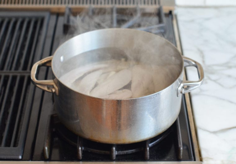 adding the chicken to the hot water
