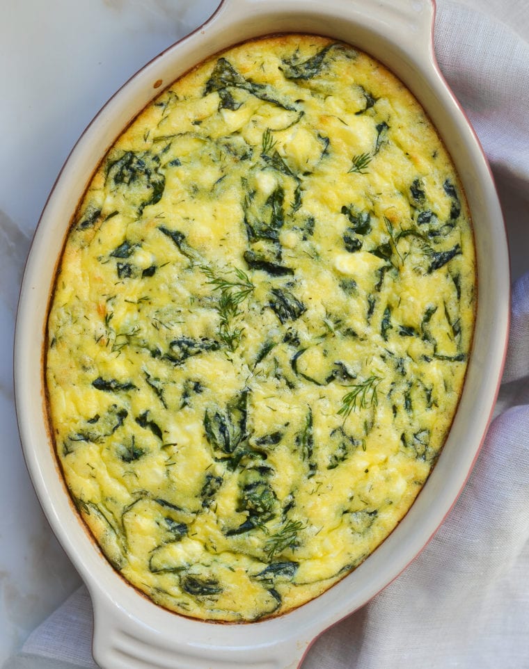 Greek-style spinach, feta, and polenta pie in a baking dish.