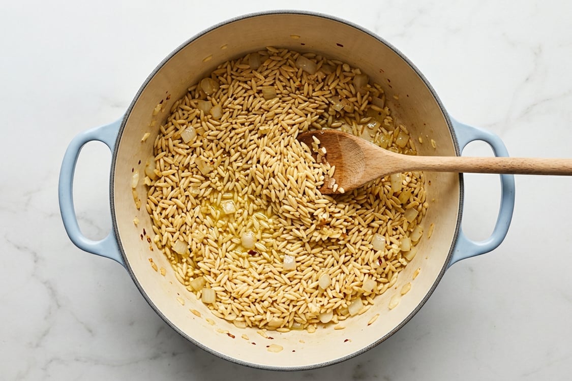 Toasting the orzo in a Dutch oven.