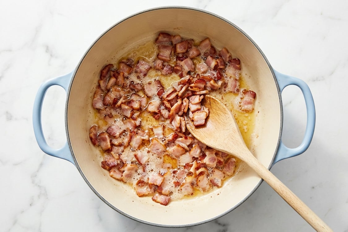 Bacon sizzling in Dutch oven.