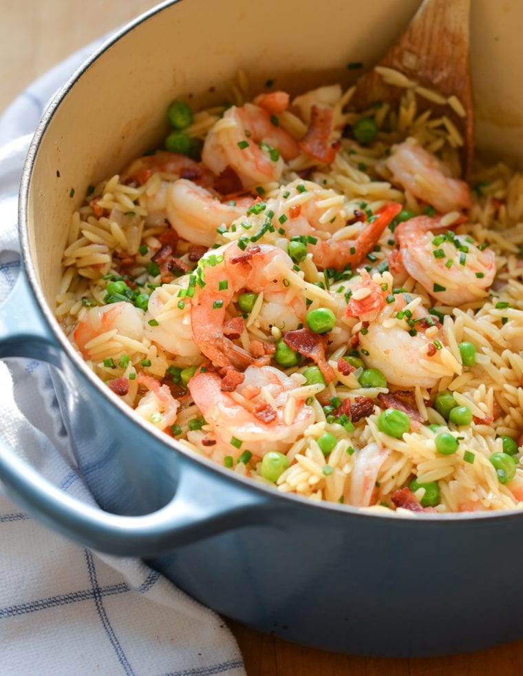 Dutch oven of orzo risotto with shrimp, peas, and bacon.
