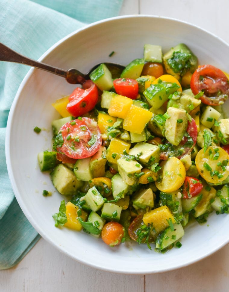 Spoon in a bowl of summer avocado salad.