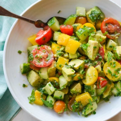 Spoon in a bowl with a summer avocado salad.