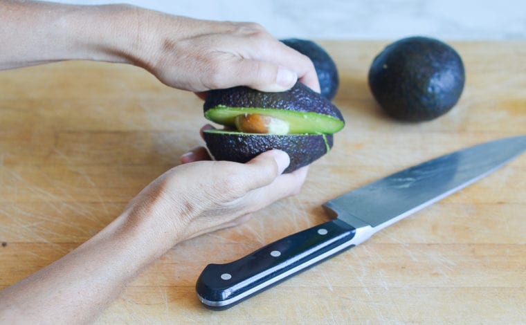 pulling the avocado halves apart
