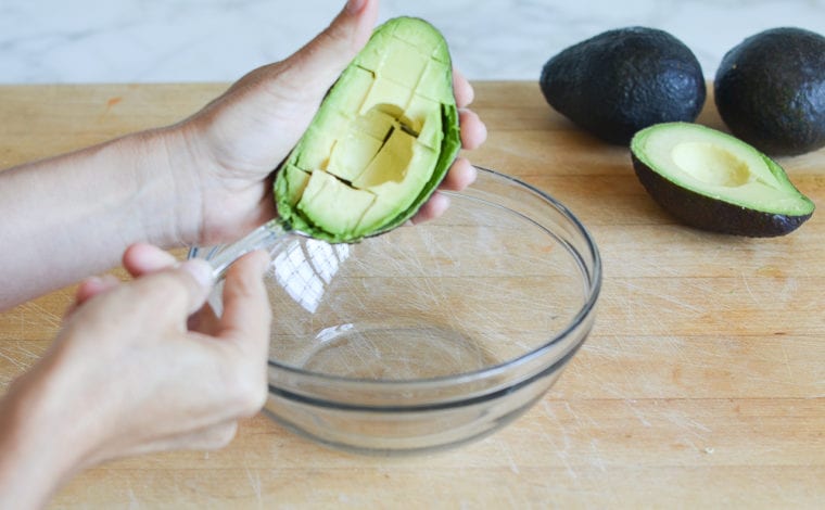 spooning out the avocado flesh