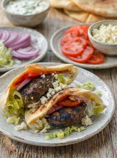 Lamb burgers on a plate with all the fixings.