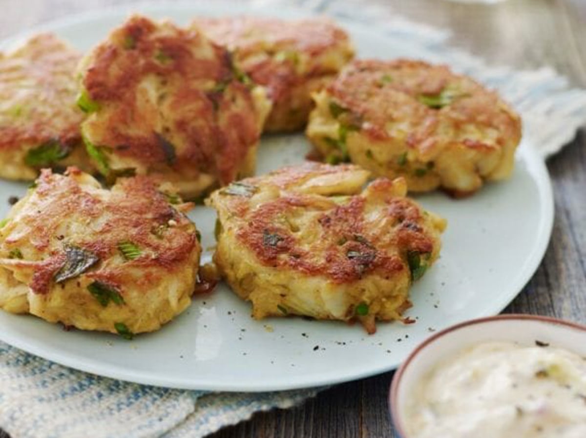 crab cakes on platter with tartar sauce on the side