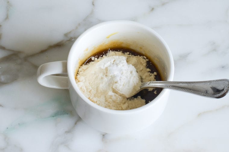 adding flour and baking soda to the mug