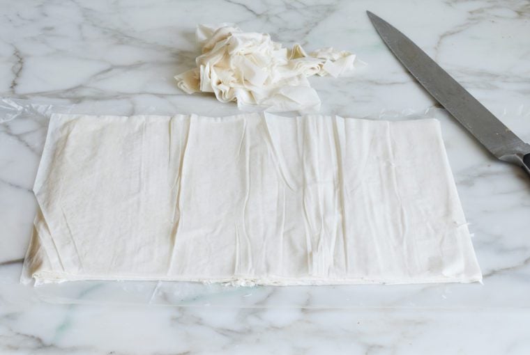 trimming phyllo dough to make baklava