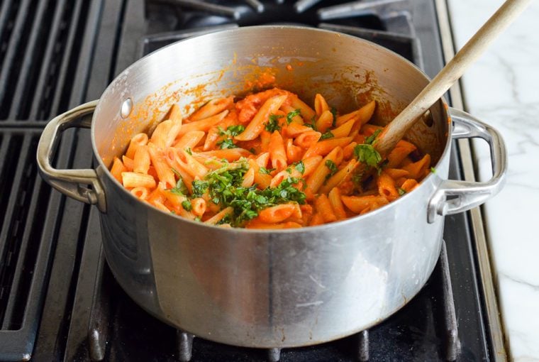 adding basil to penne alla vodka