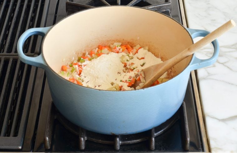 adding flour to vegetables