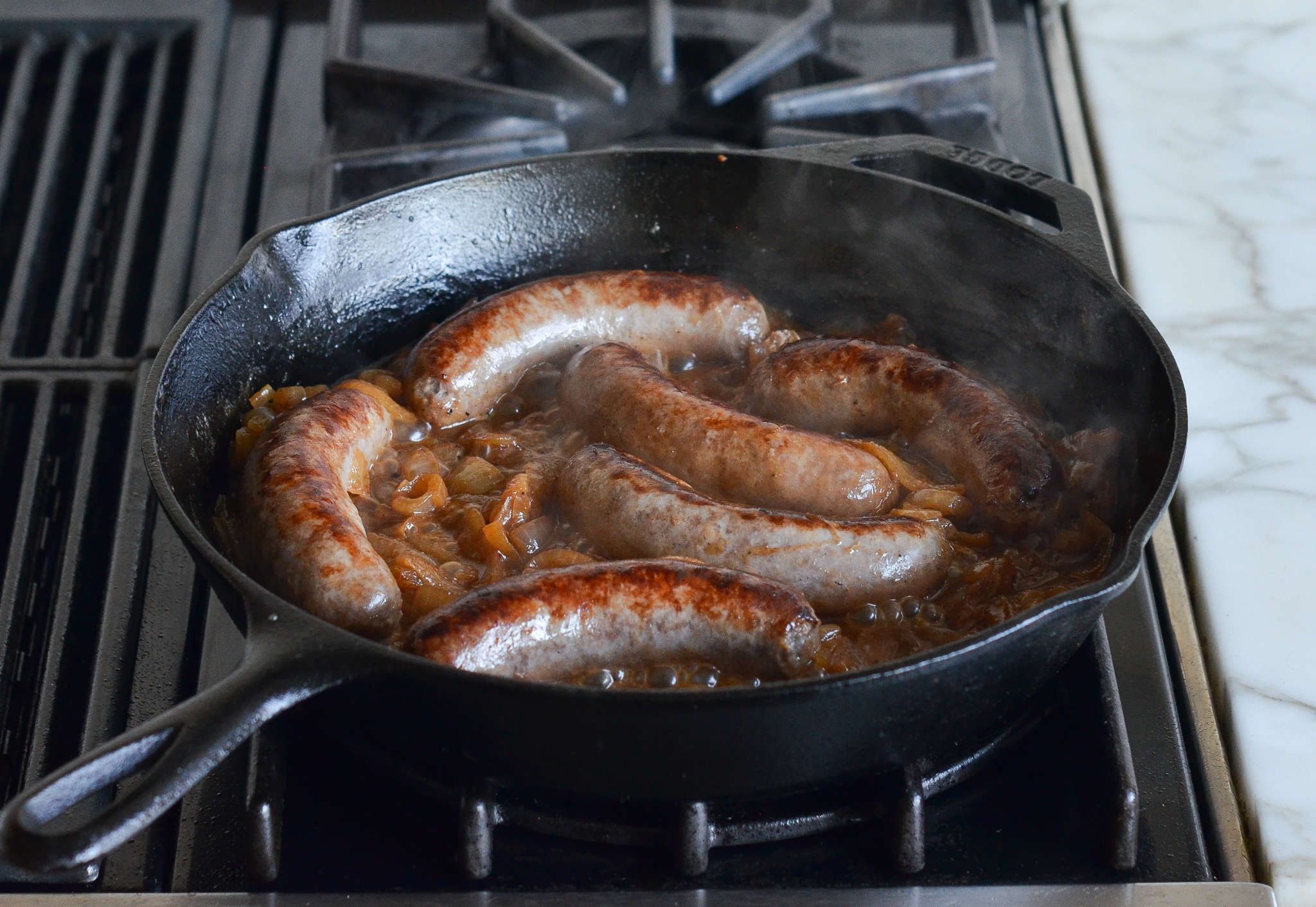 Finished bratwurst and onions in skillet.