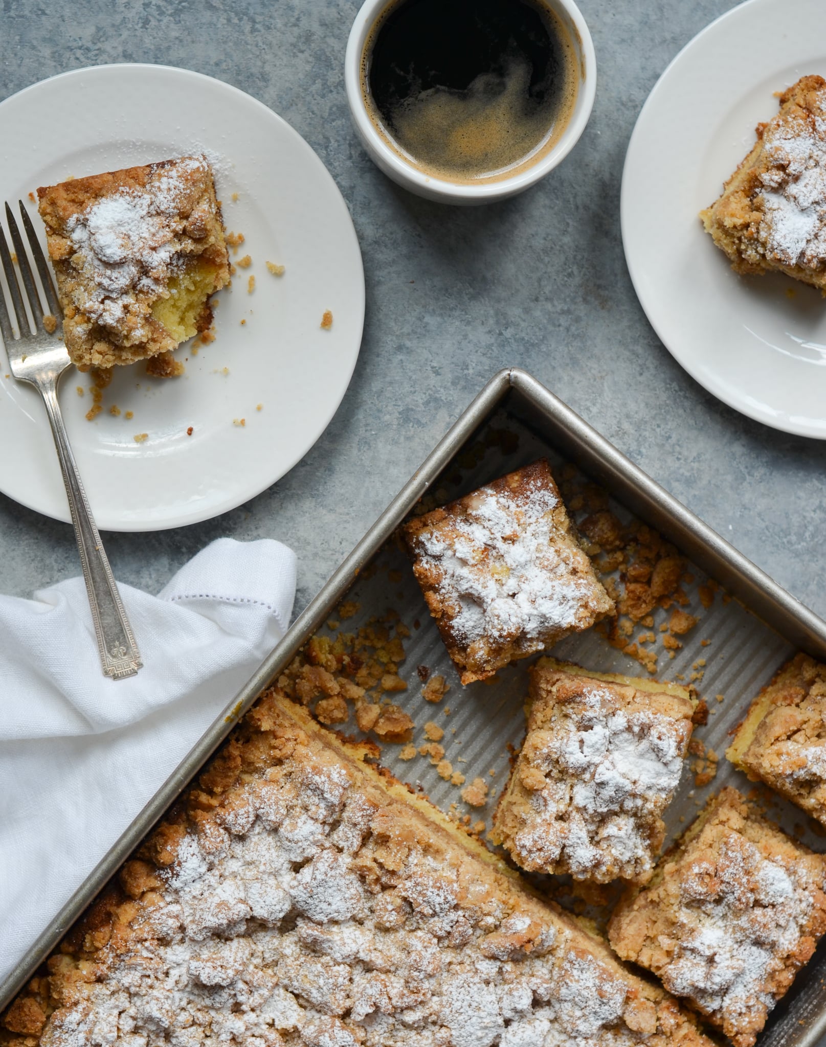 Pieces of crumb cake on plates and in a baking dish.