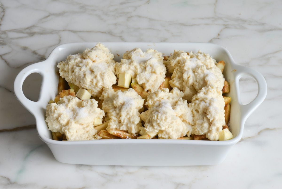 apple cobbler with biscuit topping added and ready to bake