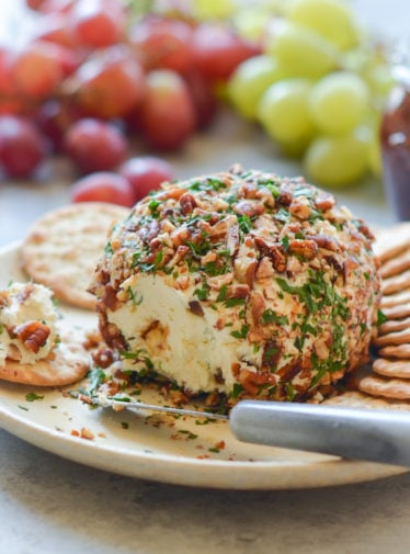 Cheese ball on a plate with crackers.