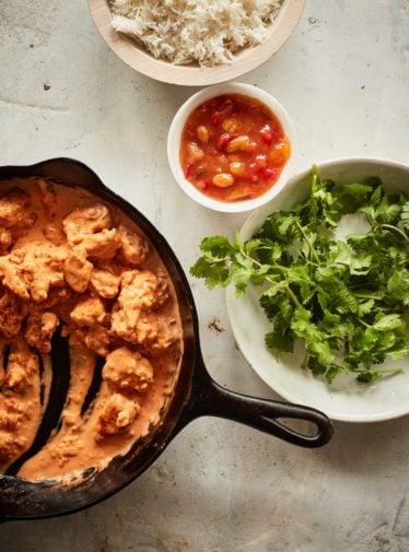 Mostly-served skillet of butter chicken.