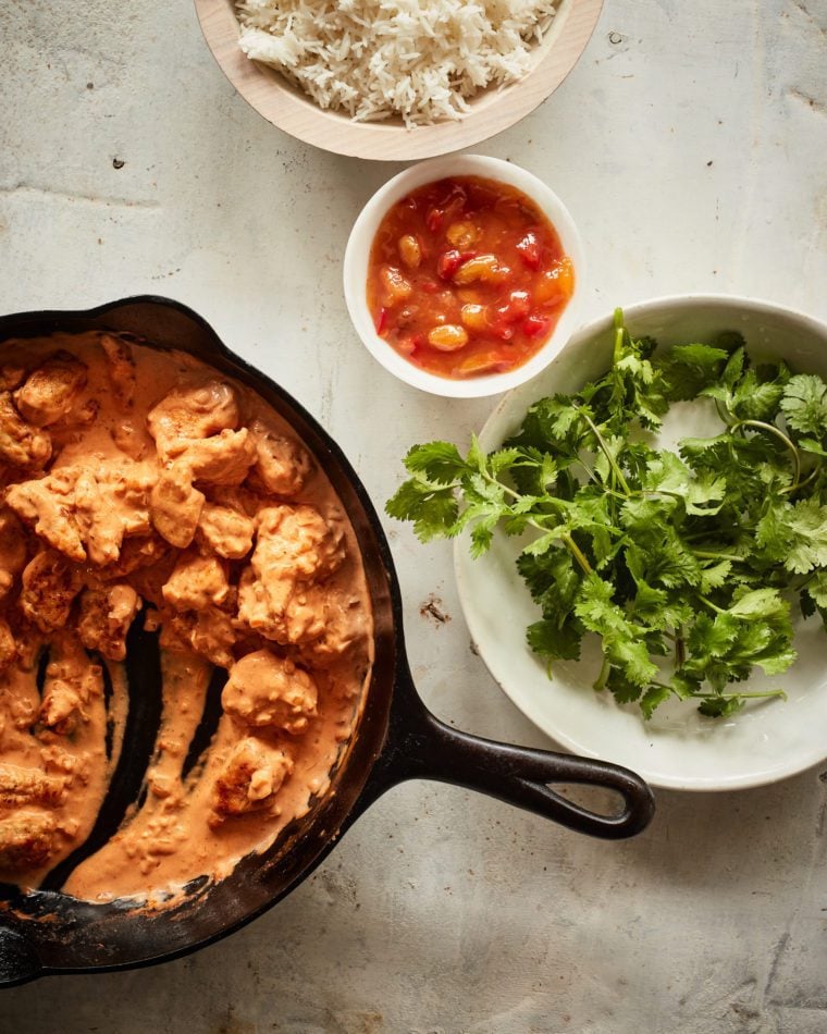 Mostly-served skillet of butter chicken.