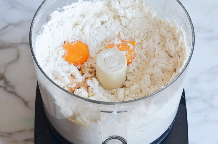 crumbly linzer cookie mixture with egg yolks, vanilla, and almond extract added