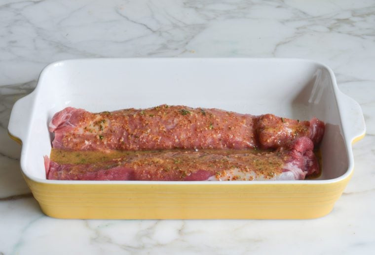 pork tenderloins coated with salt and marinade in dish