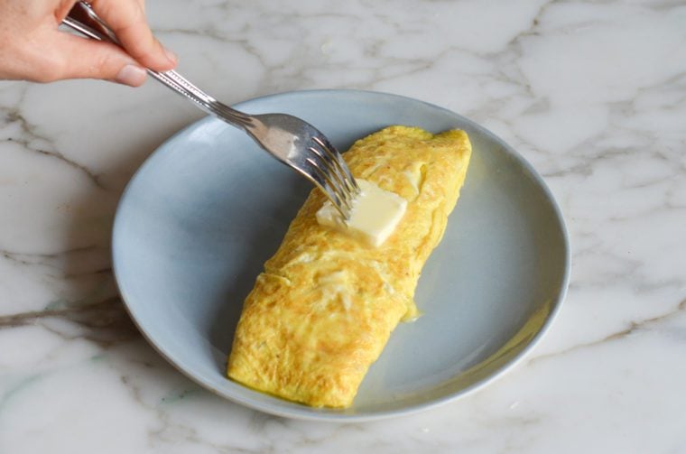 glossing the omelette with butter