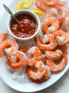 shrimp cocktail and cocktail sauce on a plate over ice.
