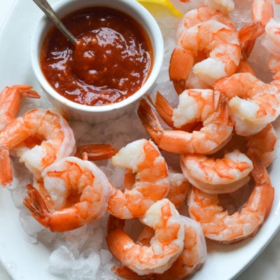 shrimp cocktail and cocktail sauce on a plate over ice.
