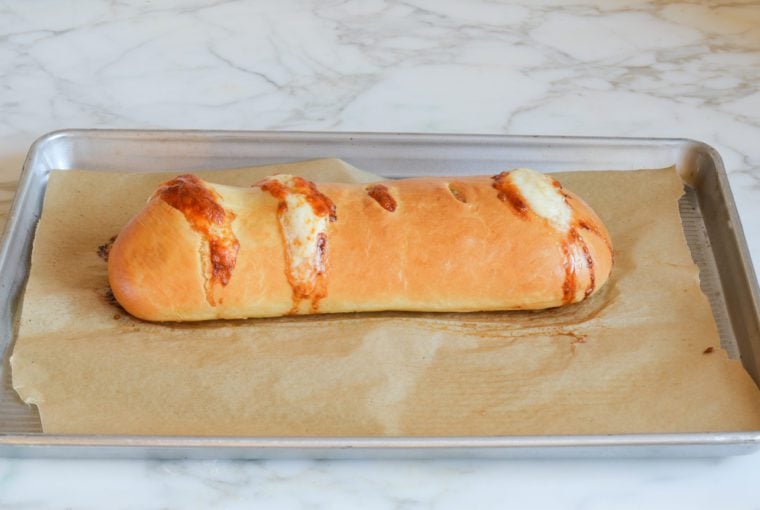 Baked stromboli on a lined baking sheet.