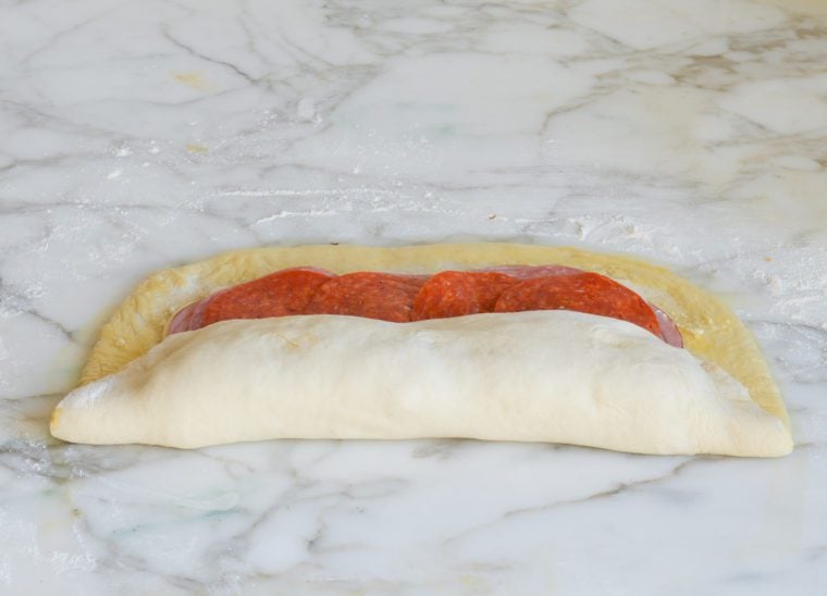 Dough being rolled around stromboli fillings.