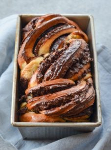 Loaf of chocolate babka in a bread pan.