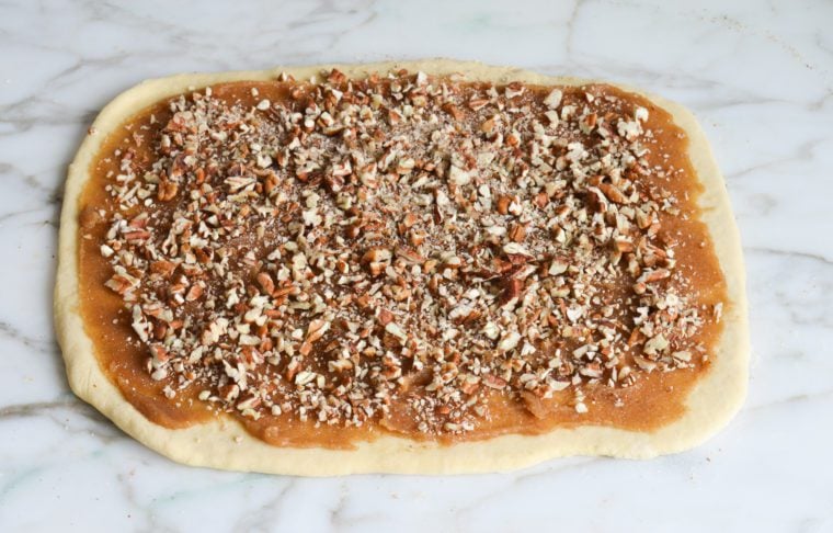 caramel and chopped pecans on dough
