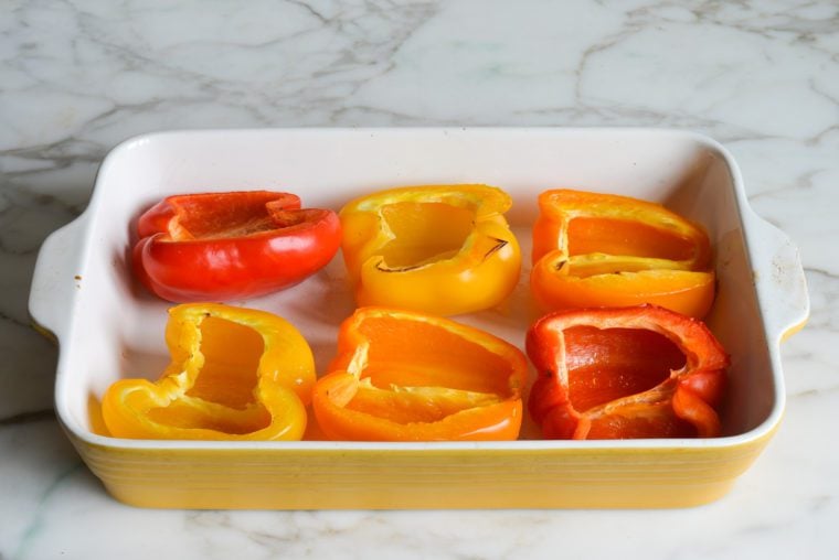 Roasted pepper halves in a baking dish.